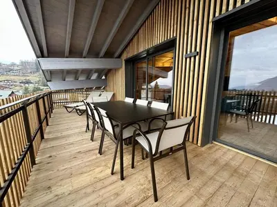 a table and chairs on the balcony of a house at Appartement de standing, au pied des pistes avec parking et WIFI, Les Carroz d'Arâches - FR-1-572-280 in Arâches-la-Frasse