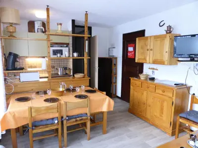 a kitchen with a wooden table with chairs and a kitchen with a refrigerator at Résidence Bel'aval - Bel Aval 195 MAE-6364 in Les Contamines-Montjoie