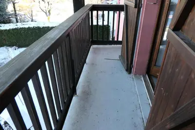 a porch with a wooden railing and snow on the ground at Résidence Les Bruyeres - Bruyères 4 MAE-6354 in Saint-Gervais-les-Bains