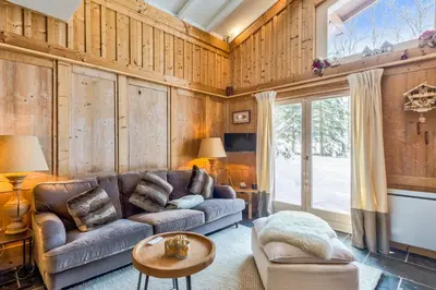a living room with a couch and a table at La Suite Darray - Welkeys in Megève