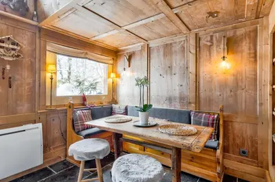 a dining room with a table and chairs at La Suite Darray - Welkeys in Megève