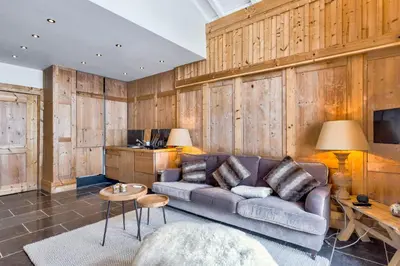 a living room with a couch and a tv at La Suite Darray - Welkeys in Megève