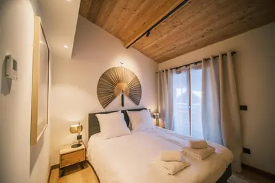 a bedroom with a bed and a tv on a wall at Loft Zodiak -Centre Ville 4 Chambres Vue in Les Houches