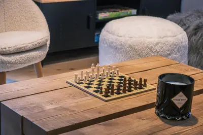 a chess board on a wooden table with a cup at Loft Zodiak -Centre Ville 4 Chambres Vue in Les Houches