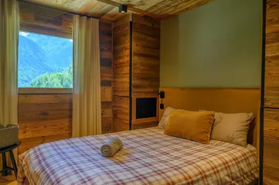 a bedroom with a bed with a large window at CHALET UTOPIA in Saint-Gervais-les-Bains