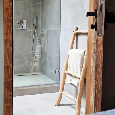 a shower with a glass door with a chair in a bathroom at CHALET UTOPIA in Saint-Gervais-les-Bains