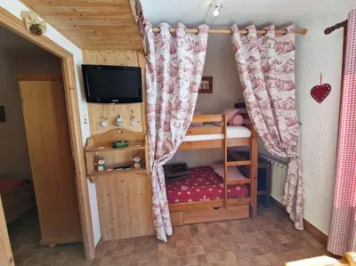 a small room with a bunk bed and a tv at Appartement - Vue Mont-Blanc in Cordon
