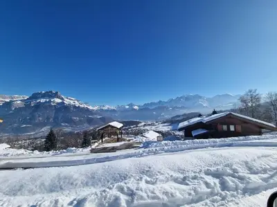 a snow covered mountain with a house in the background at Appartement - Vue Mont-Blanc in Cordon