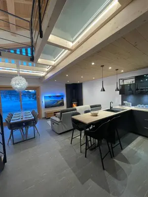 a kitchen and living room with a table and chairs at Chalet Clos du Nant Megève in Demi-Quartier