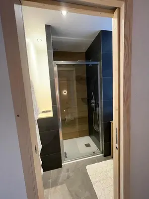 a shower with a glass door in a bathroom at Chalet Clos du Nant Megève in Demi-Quartier