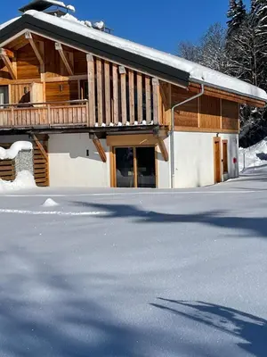 a building with a snow covered street in front of it at Chalet Clos du Nant Megève in Demi-Quartier