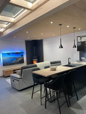 a kitchen and living room with a table and a couch at Chalet Clos du Nant Megève in Demi-Quartier
