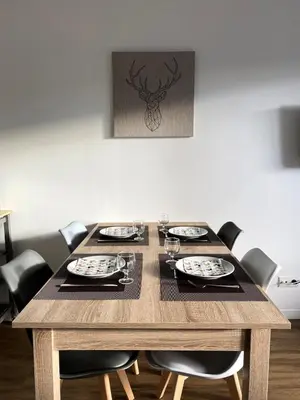 a wooden table with chairs and plates and glasses at Résidence Les Pleiades - Appartement rénové · Centre station · Balcon · Parking couvert MAE-8234 in Magland