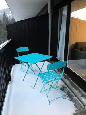 two blue chairs and a table on a balcony at Résidence Les Pleiades - Appartement rénové · Centre station · Balcon · Parking couvert MAE-8234 in Magland