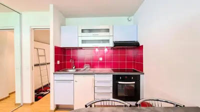 a kitchen with a sink and a red tile wall at Résidence Andromede - Studio entièrement rénové · Proche des pistes MAE-8254 in Magland