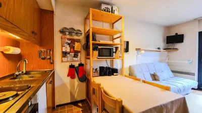 a small kitchen with a counter and a blue chair at Résidence Andromede - Studio agréable avec casier à ski · Proche des pistes · Balcon MAE-4274 in Magland