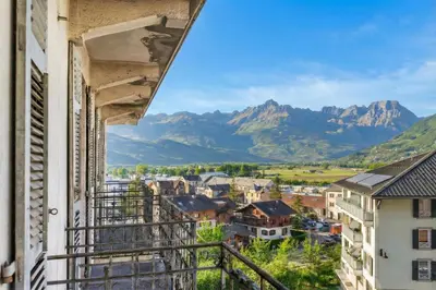 a view of mountains from a balcony with snow covered buildings at Résidence du Parc - Happy Rentals in Saint-Gervais-les-Bains