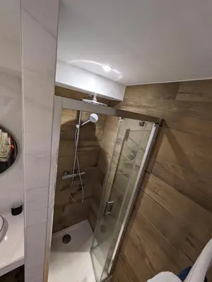 a shower with a glass door in a bathroom at Le Sasha in Chamonix-Mont-Blanc