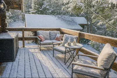 two chairs and a table on a deck with snow at Mazot cozy chalet spirit in Chamonix in Chamonix-Mont-Blanc