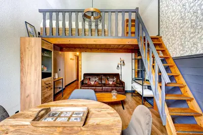 a living room with a loft bed and a table at Superbe appartement hyper-centre in Chamonix-Mont-Blanc