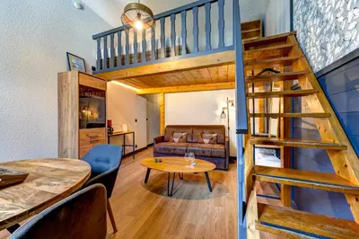 a living room with a staircase and a living room at Superbe appartement hyper-centre in Chamonix-Mont-Blanc