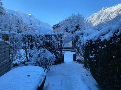 a snow covered path with trees and a house at Mer de Glace in Chamonix-Mont-Blanc