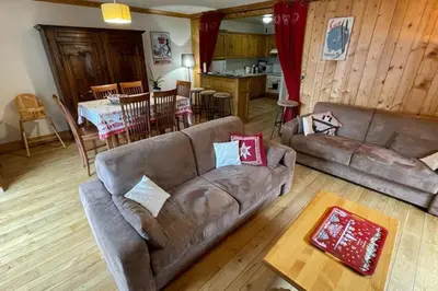 a living room with couches and a kitchen and a table at Large apartment in Chamonix - close to the slopes in Chamonix-Mont-Blanc