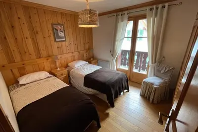 a small bedroom with a bed and wooden cabinets at Large apartment in Chamonix - close to the slopes in Chamonix-Mont-Blanc