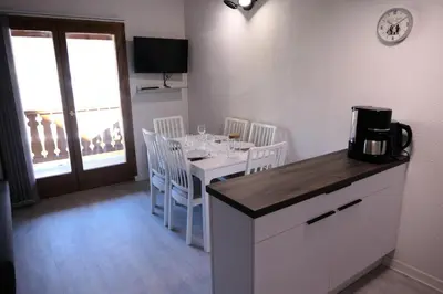 a dining room with a table with chairs and a kitchen at Résidence Hameau De Coterat - Hameau de Coterat 11 MAE-2524 in Saint-Gervais-les-Bains