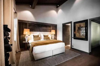 a bedroom with a large bed and two lamps at Chalet Apollo in Megève