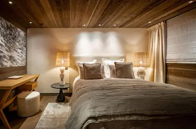 a bedroom with a large bed and two lamps at Chalet Apollo in Megève