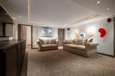 a living room with two couches and a kitchen at Chalet Apollo in Megève