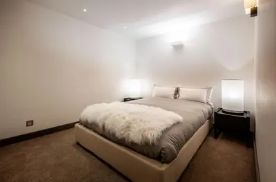 a bedroom with a white bed with two lamps at Chalet Apollo in Megève