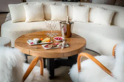a coffee table with food and glasses on a couch at Chalet Apollo in Megève