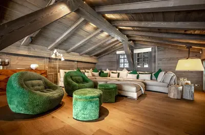 a living room with green chairs and a couch at Chalet Apollo in Megève