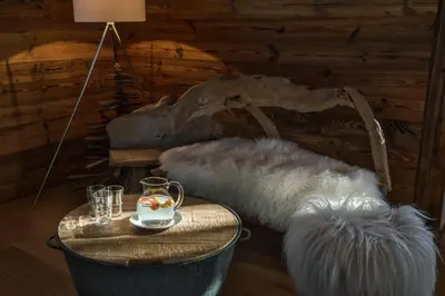 a room with a bed with faux fur cushions at Chalet Eisstock in Megève