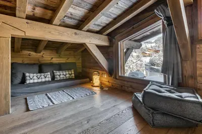 a living room with a couch and a window at Chalet Eisstock in Megève