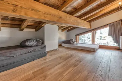 a living room with a couch and a large window at Chalet Eisstock in Megève
