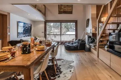 a dining room and living room with a large wooden table at Yupik in Megève