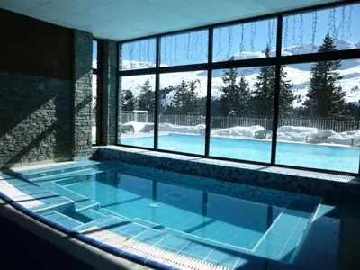 a hot tub in a room with a large window at Résidence Les Terrasses D'eos - Appartement confortable · Accès direct aux pistes · Piscine · Spa · WIFI gratuit et illimité MAE-6164 in Magland