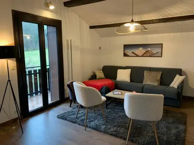 a living room with a couch and a table and chairs at Duplex 3 chambres Vue Mont-Blanc in Domancy