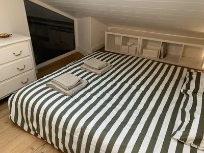 a bedroom with a striped bed with two towels on it at Duplex 3 chambres Vue Mont-Blanc in Domancy