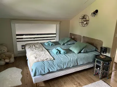 a bedroom with a bed with blue sheets and a window at Duplex 3 chambres Vue Mont-Blanc in Domancy