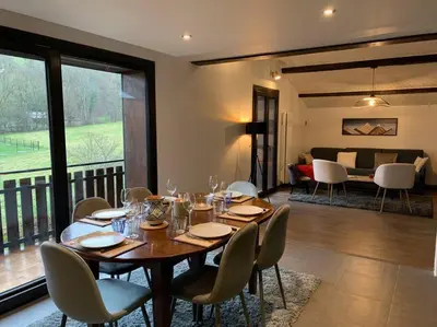 a dining room with a table and chairs and a living room at Duplex 3 chambres Vue Mont-Blanc in Domancy