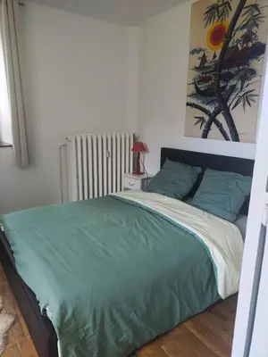 a bedroom with a bed with a green blanket at LaResidence in Saint-Gervais-les-Bains