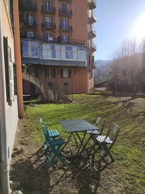a picnic table and two chairs in a yard with a building at LaResidence in Saint-Gervais-les-Bains