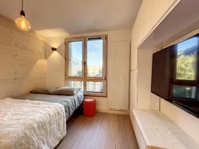 a bedroom with a bed and a flat screen tv at Superbe studio refait à neuf et tout équipé avec parking in Chamonix-Mont-Blanc