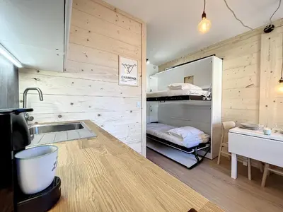 a kitchen with a sink and a bunk bed at Superbe studio refait à neuf et tout équipé avec parking in Chamonix-Mont-Blanc