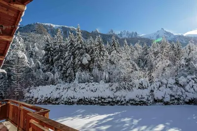a bedroom with a large white bed and a desk at Chalet le Tricouni in Chamonix-Mont-Blanc