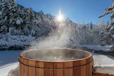 a kitchen with black cabinets and a wooden floor at Chalet le Tricouni in Chamonix-Mont-Blanc